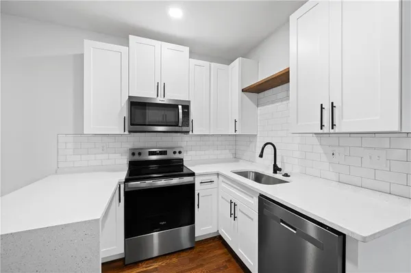 a kitchen with a sink stove and microwave