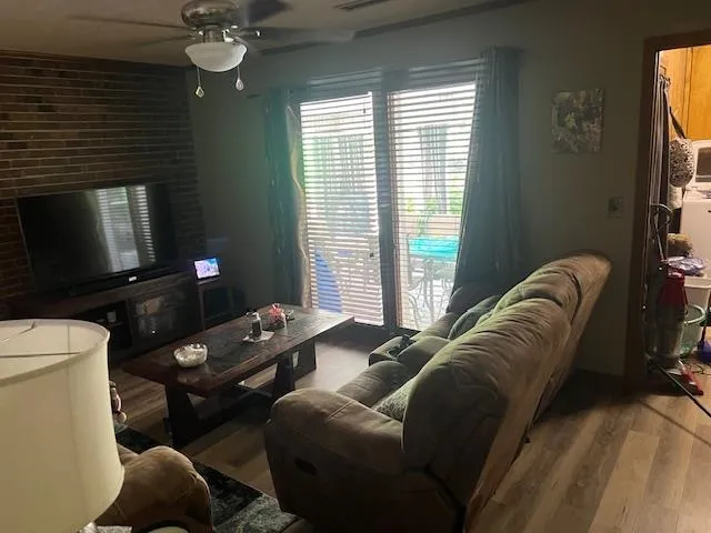 a living room with furniture a flat screen tv and a window