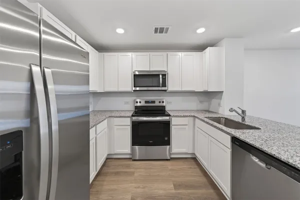 a kitchen with a sink stove and refrigerator
