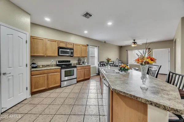 a kitchen with kitchen island granite countertop a sink and white cabinets
