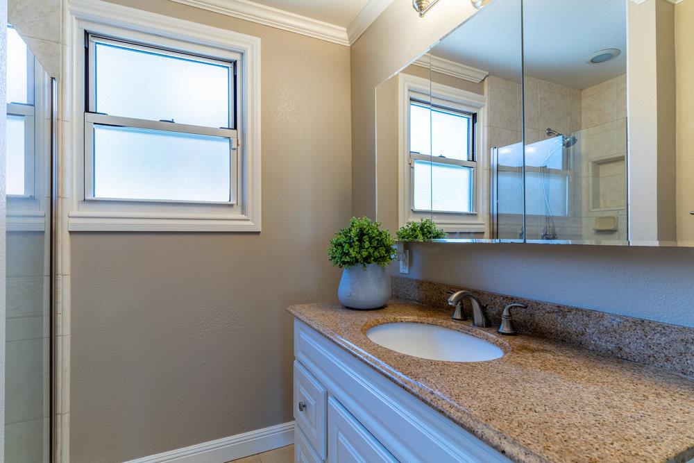14832 Acton Drive San Jose, CA 95124 - Photo 18 of 47 a bathroom with a granite countertop sink a mirror and next to a window