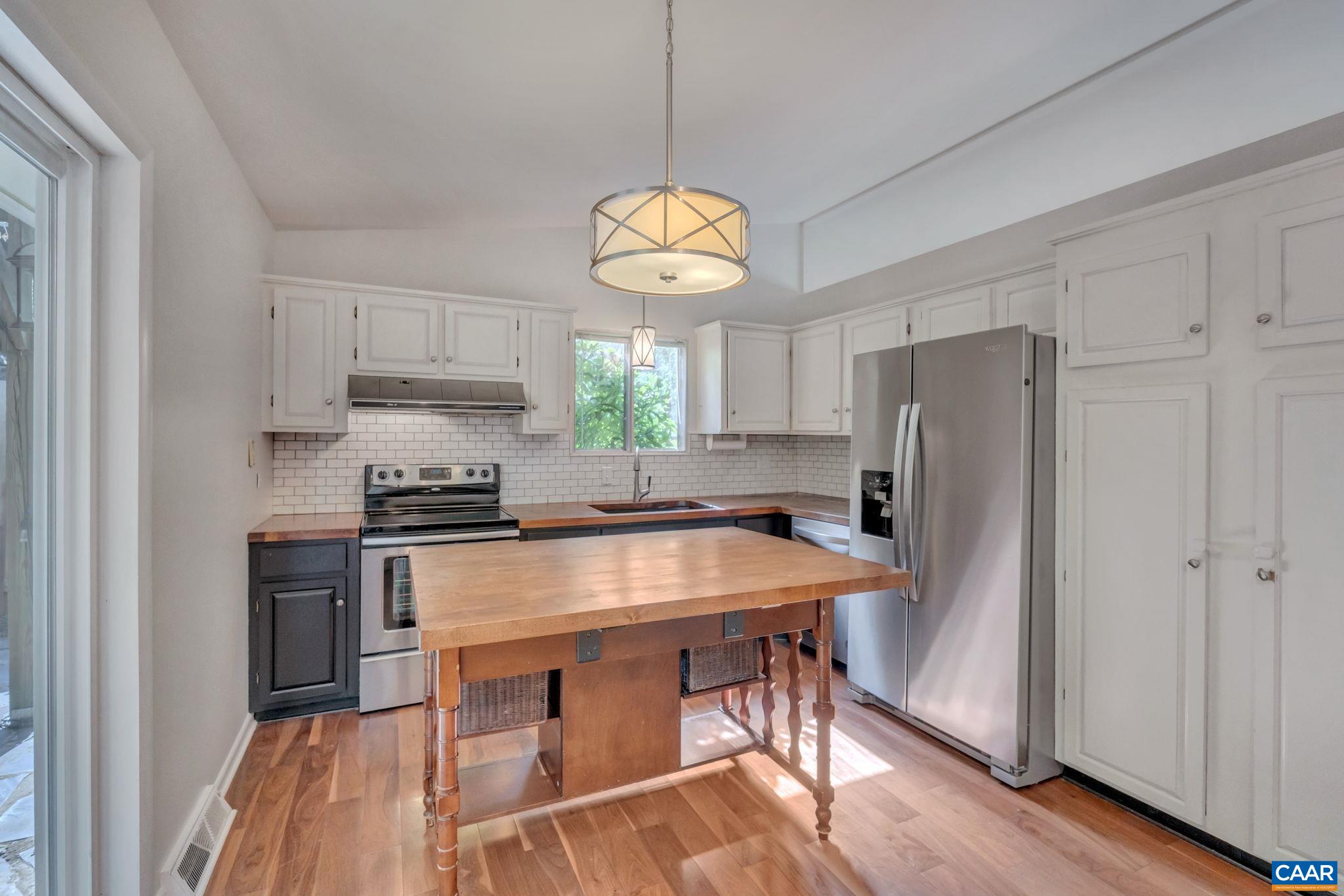 707 Village Road Charlottesville, VA 22903 - Photo 15 of 46 a kitchen with stainless steel appliances a stove a refrigerator and a sink with wooden floor