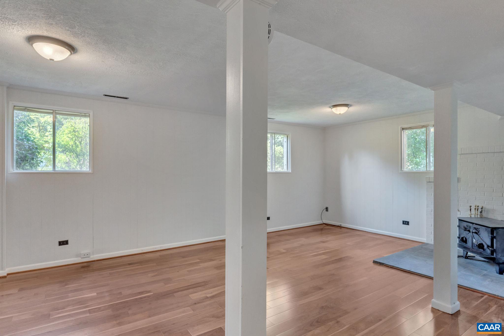 707 Village Road Charlottesville, VA 22903 - Photo 29 of 46 an empty room with wooden floor and windows