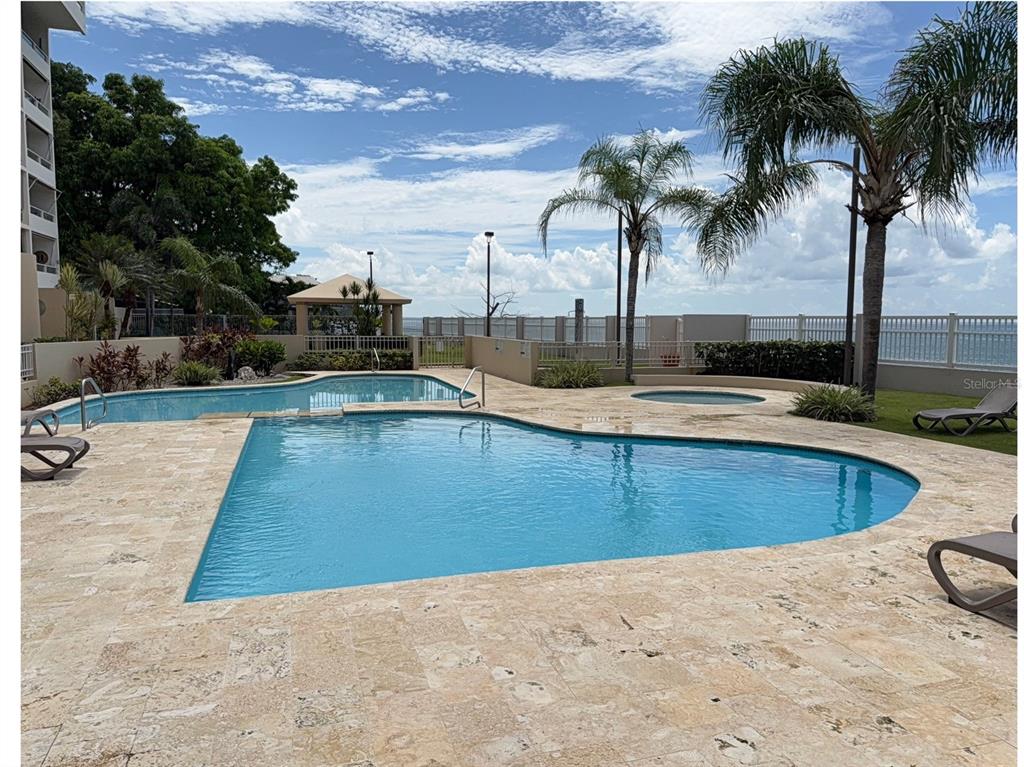Condo Pelican Reef Condo Pelican Reef, Unit 302 Rincon, PR 00677 - Photo 10 of 16 a view of a swimming pool with a lounge chair