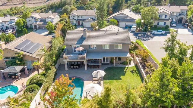 a aerial view of a house with swimming pool and large trees