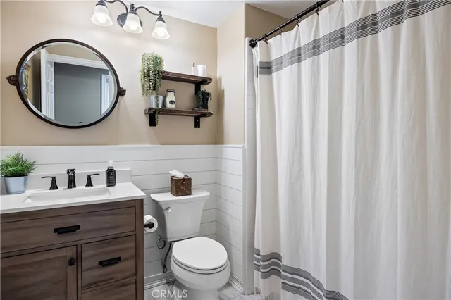 a large bed with a lamp on dresser