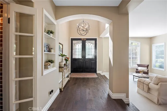 a kitchen with stainless steel appliances granite countertop a stove a refrigerator a sink a stove and white cabinets with wooden floor