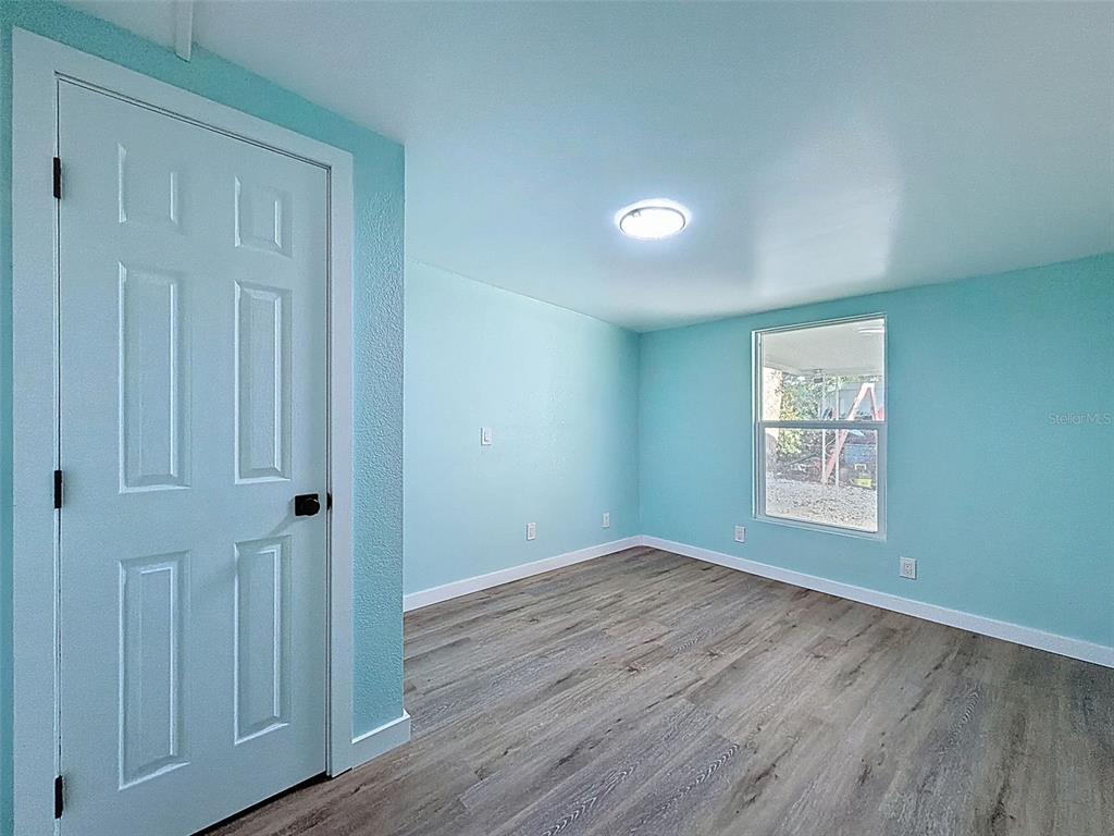 6827 Sanderling Lane Hudson, FL 34667 - Photo 16 of 68 an empty room with wooden floor and windows