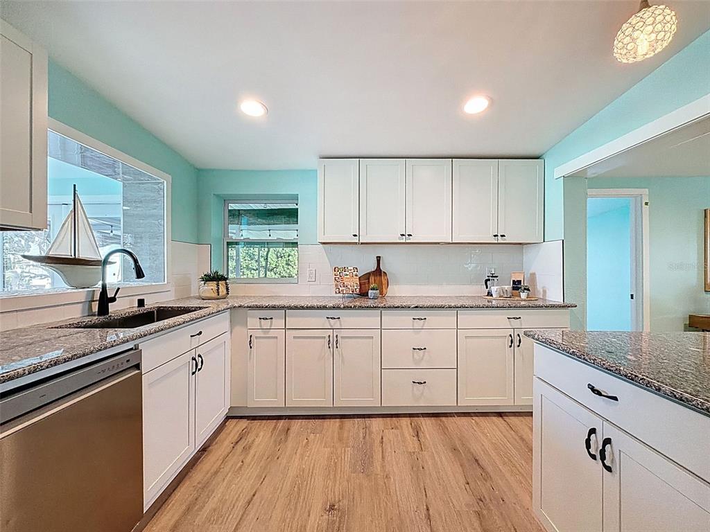 6827 Sanderling Lane Hudson, FL 34667 - Photo 6 of 68 a kitchen with granite countertop white cabinets and white appliances