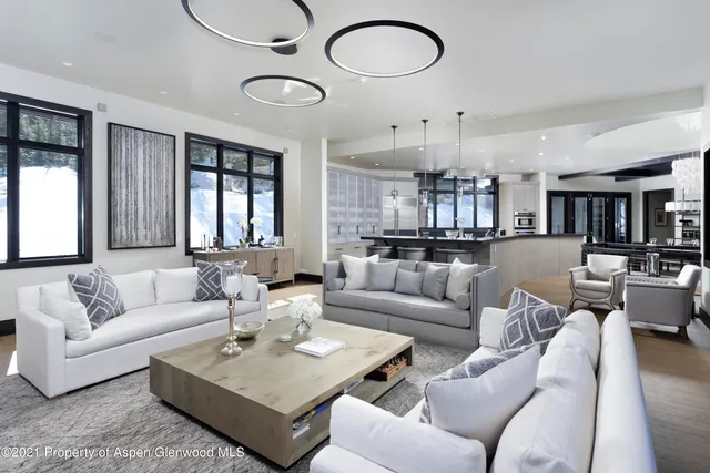 a living room with furniture kitchen view and a large window
