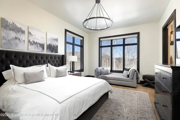 a bedroom with a bed and a chandelier