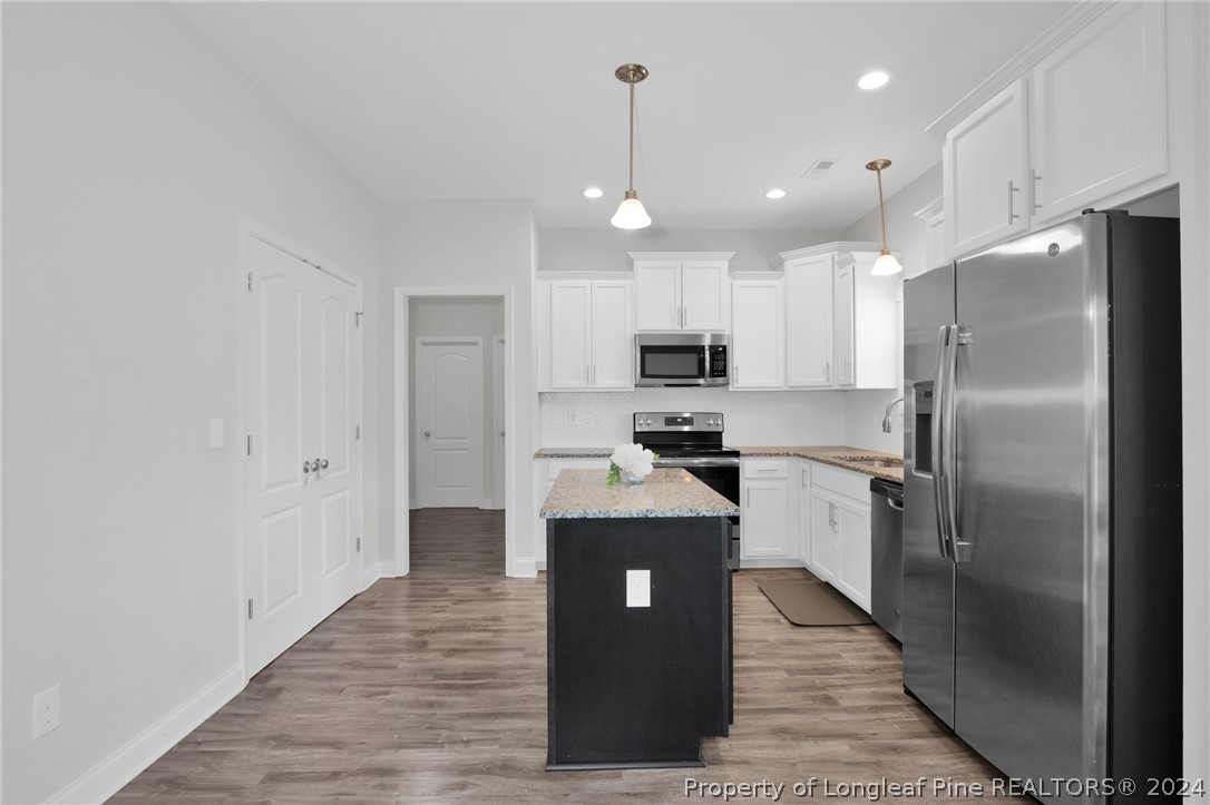 9670 East Reeves Bridge Road Linden, NC 28356 - Photo 12 of 35 a kitchen with stainless steel appliances granite countertop a refrigerator a sink and a stove
