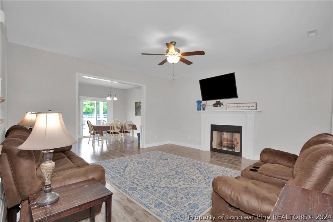 9670 East Reeves Bridge Road Linden, NC 28356 - Photo 6 of 35 a living room with furniture a fireplace and a flat screen tv