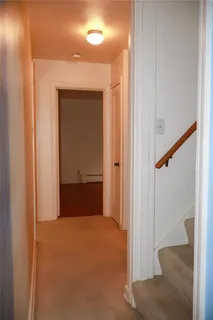 a view of a hallway with wooden floor and entryway