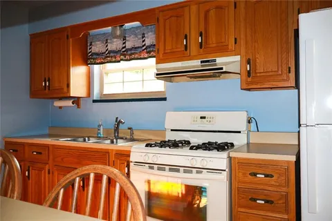 a kitchen with stainless steel appliances granite countertop a stove a sink dishwasher and cabinets with wooden floor