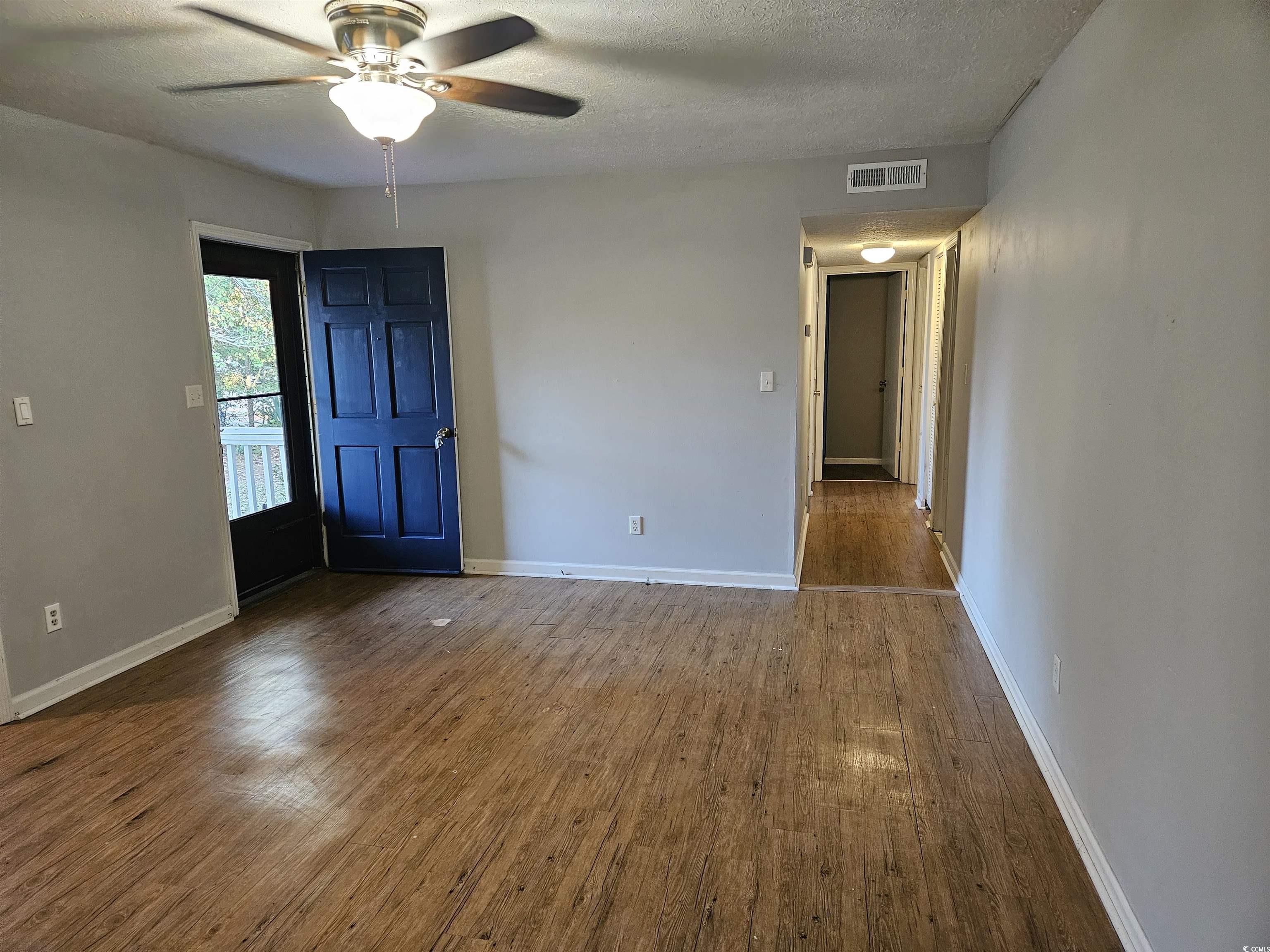 602 Jefferson Way Conway, SC 29526 - Photo 12 of 20 Spare room with dark wood-style floors, a textured ceiling, and ceiling fan