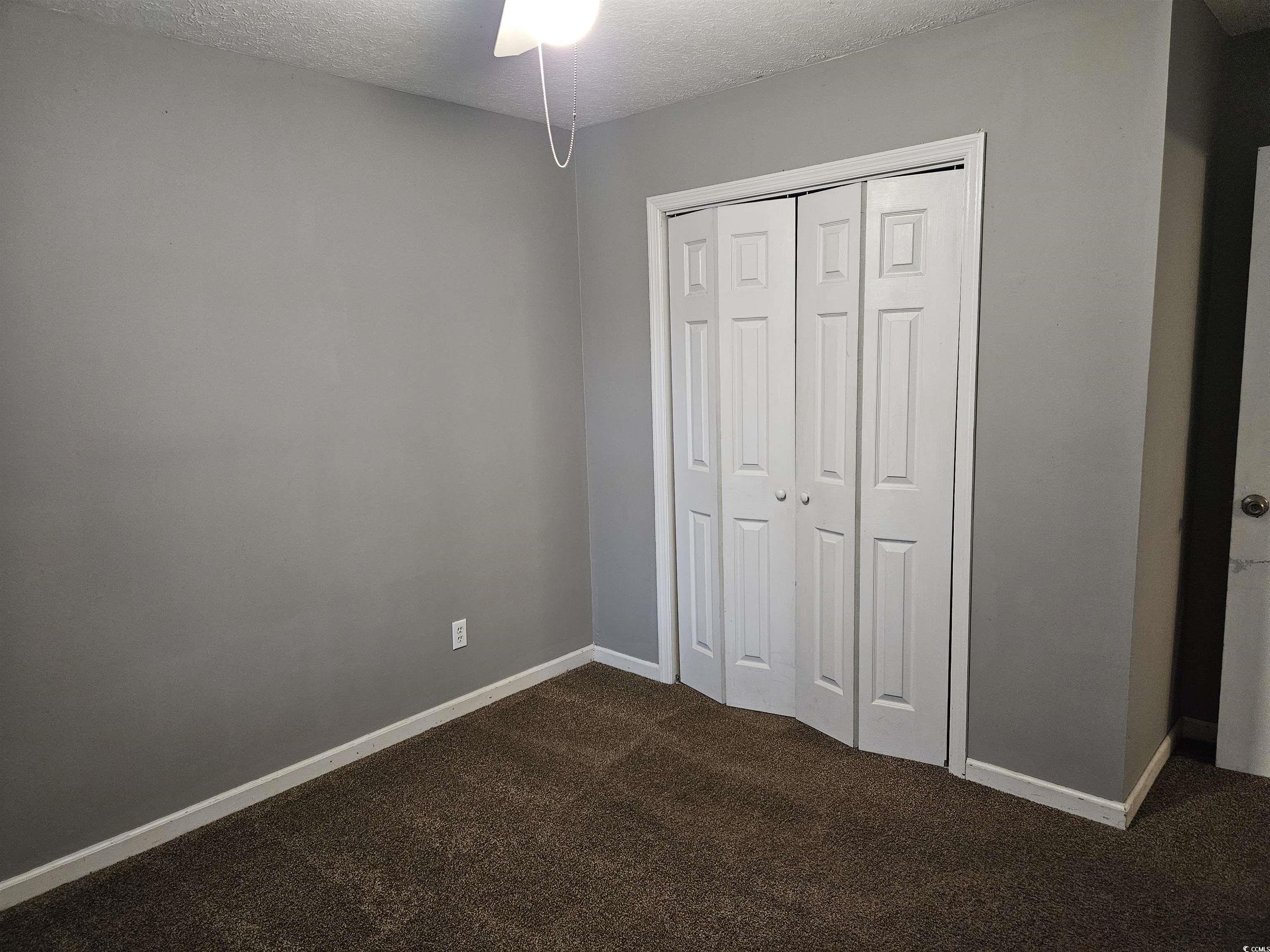 602 Jefferson Way Conway, SC 29526 - Photo 17 of 20 Unfurnished bedroom featuring a textured ceiling, dark carpet, a closet, and ceiling fan