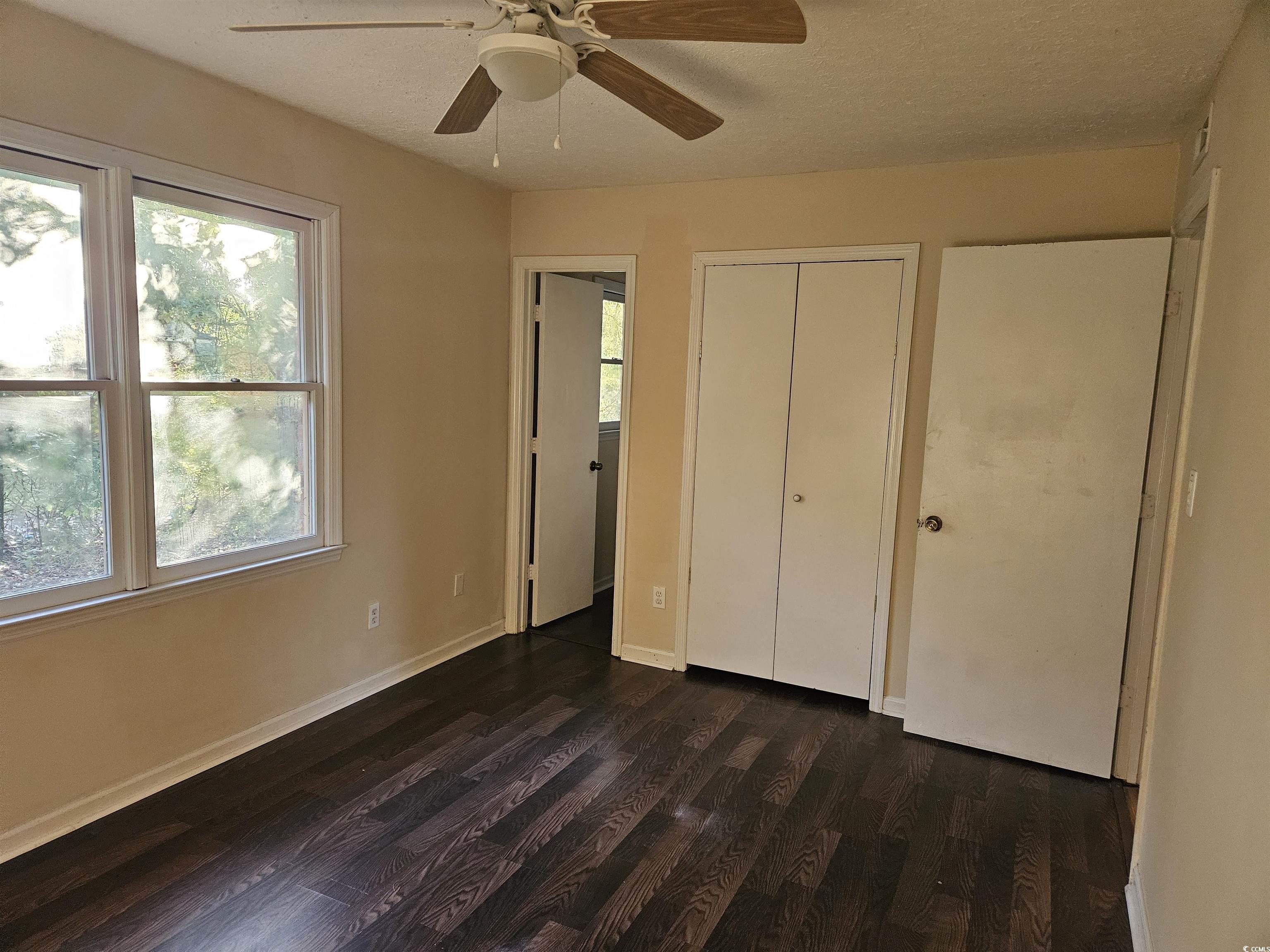 602 Jefferson Way Conway, SC 29526 - Photo 5 of 20 Unfurnished bedroom featuring multiple windows, dark wood finished floors, a closet, a textured ceiling, and ceiling fan