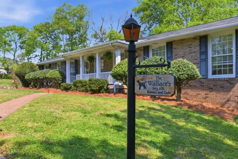 a front view of a house with porch and garden