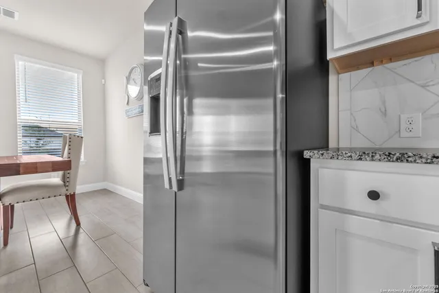 a view of kitchen with refrigerator and window