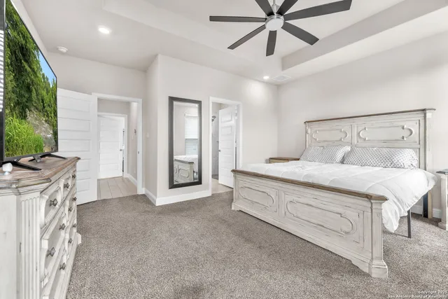 a spacious bedroom with a large bed and a chandelier