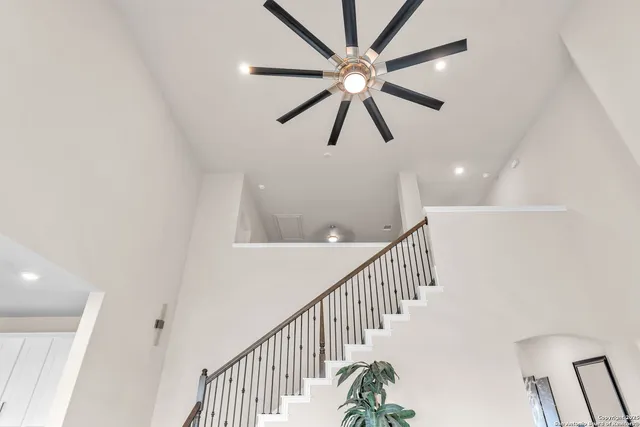 a view of staircase with wooden floor and fan
