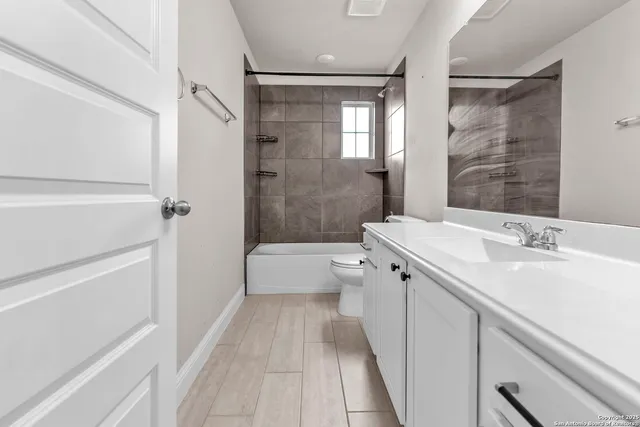 a bathroom with a sink a toilet a mirror and shower