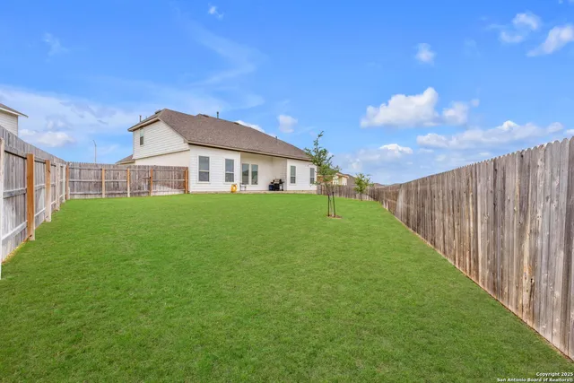 a view of a house with a big yard and large trees