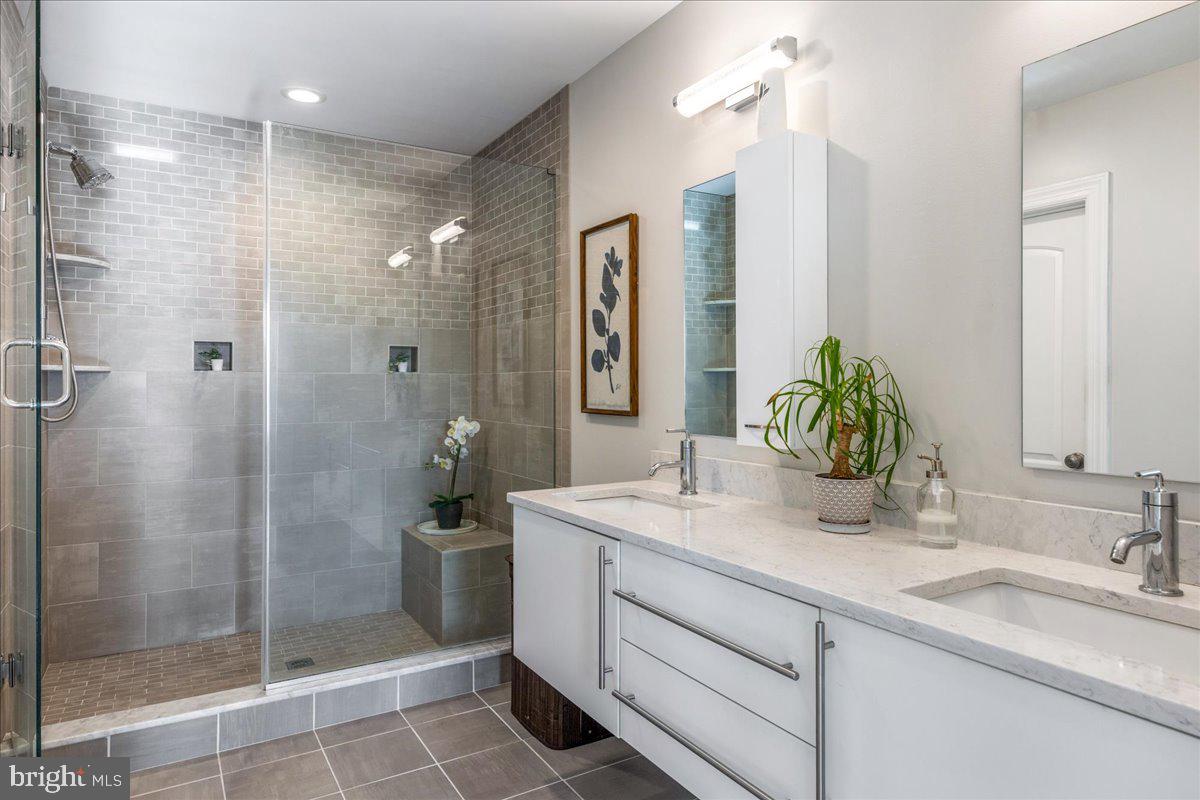 20 East Court Street Doylestown, PA 18901 - Photo 28 of 34 a bathroom with a shower sink and mirror