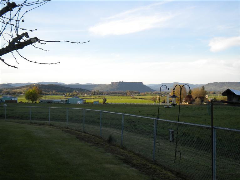 4048 Old Stage Road Central Point, OR 97502 - Photo 3 of 24 a view of a green field with house in background