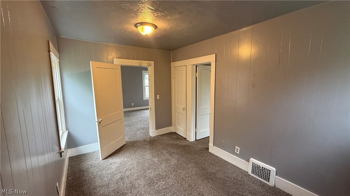 1187 Addison Road, Unit 4 Cleveland, OH 44103 - Photo 11 of 15 Carpeted interior space featuring gray vertical paneling on walls