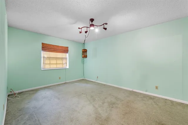 an empty room with windows and ceiling fan