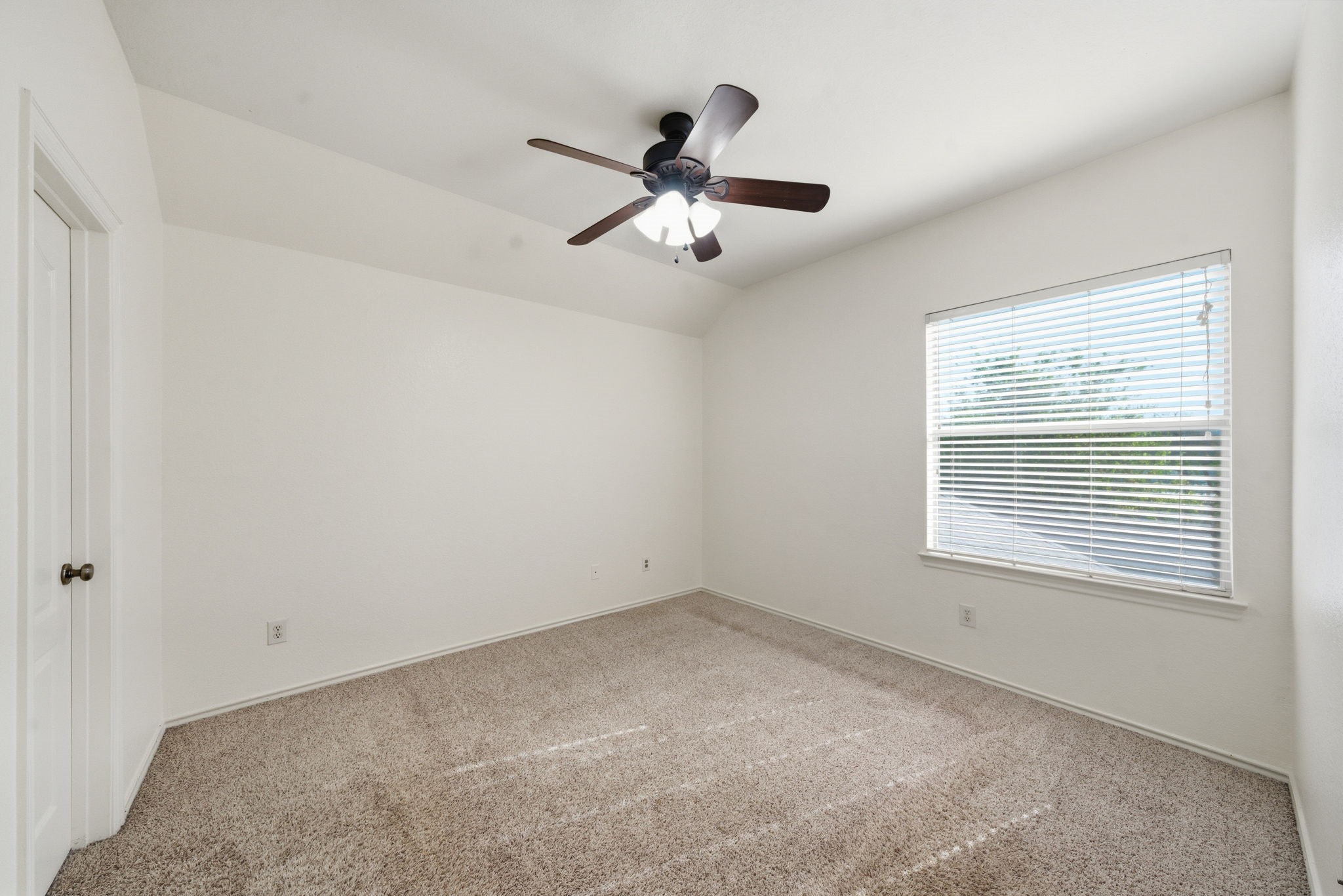 23139 Tranquil Spring Lane Katy, TX 77494 - Photo 15 of 22 Secondary Bedroom: This room is bright and spacious with neutral walls and carpet. It features a ceiling fan and a window with blinds, offering a comfortable, airy atmosphere.