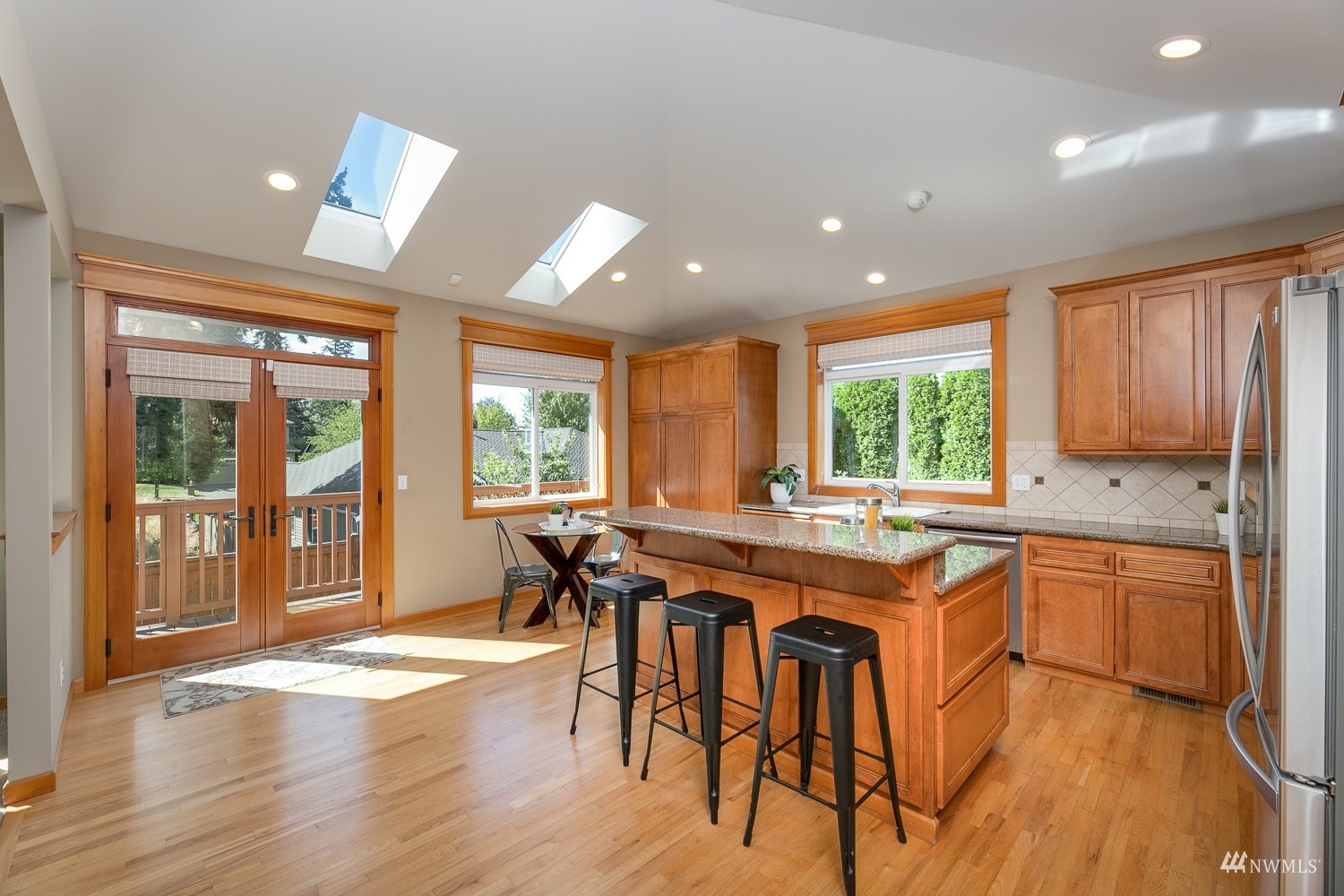 24222 23rd Avenue Southeast Bothell, WA 98021 - Photo 17 of 40 a kitchen with stainless steel appliances granite countertop wooden floor window dining table and chairs