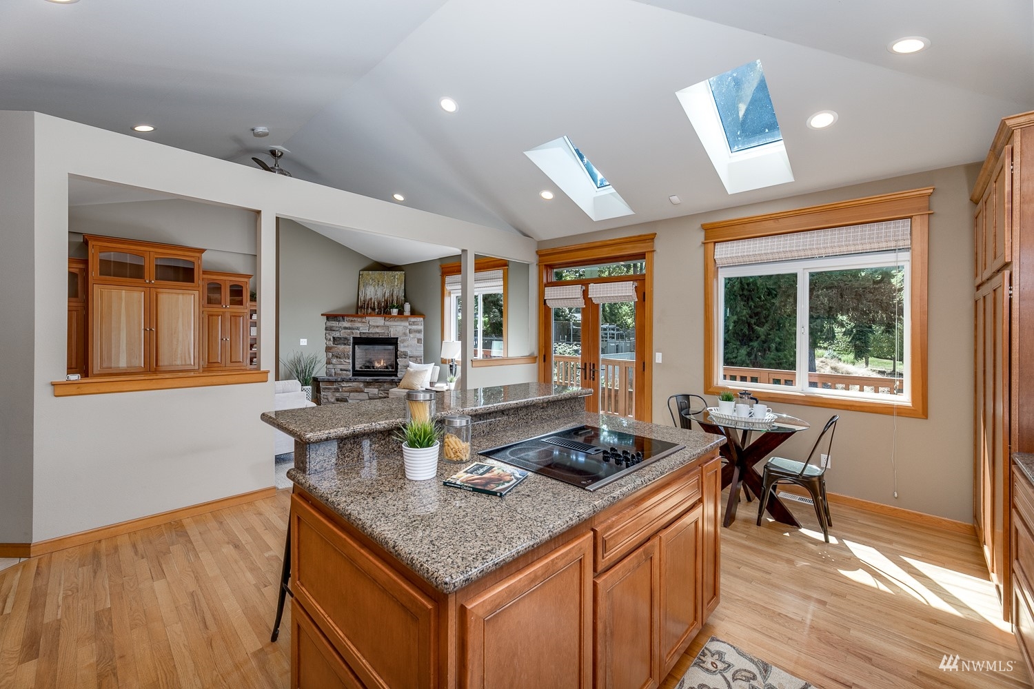 24222 23rd Avenue Southeast Bothell, WA 98021 - Photo 23 of 40 a kitchen with a stove a sink a dining table and chairs with wooden floor