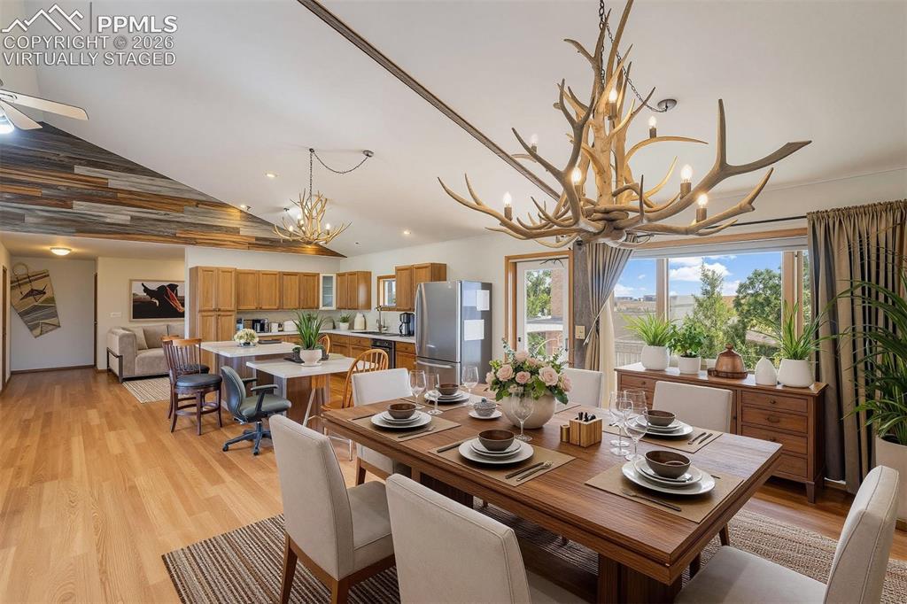 2550 Slocum Road Peyton, CO 80831 - Photo 31 of 50 virtually staged Open-concept living space featuring wood-finish flooring, a vaulted ceiling with wood paneling accents, and a kitchen with wood cabinetry and stainless steel appliances