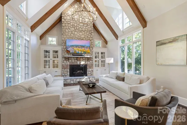 a living room with furniture a fireplace and a large window
