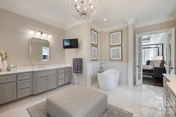 a spacious en suite bathroom with a granite countertop sink mirror and bathtub