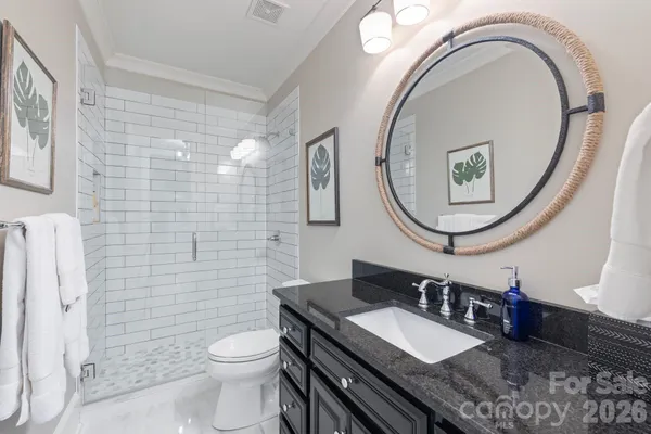a bathroom with a granite countertop toilet a sink and a mirror