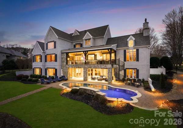 a front view of a house with yard and swimming pool