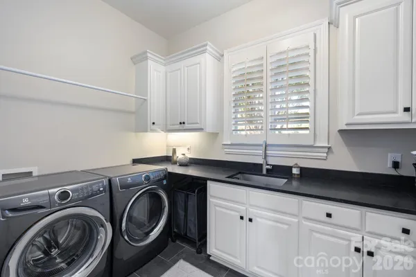 a utility room with sink and cabinets