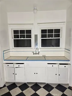 a kitchen with a checkered floor and white cabinets
