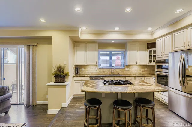 a kitchen with stainless steel appliances granite countertop a stove refrigerator sink and cabinets
