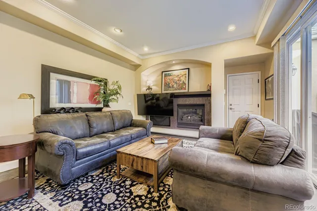 a living room with furniture a flat screen tv and a fireplace