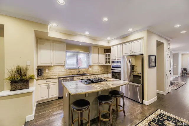 a kitchen with stainless steel appliances granite countertop a stove refrigerator sink and cabinets