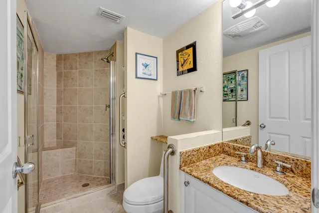 a bathroom with a granite countertop sink toilet and shower