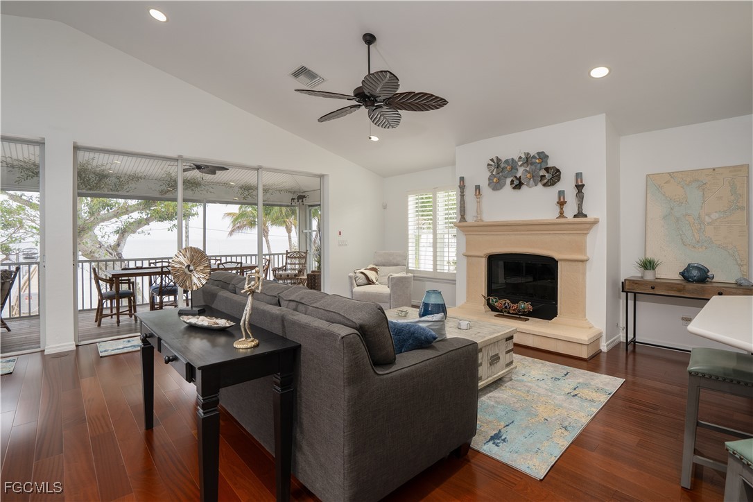8550 Ebbtide Way Bokeelia, FL 33922 - Photo 12 of 50 a living room with furniture a fireplace and a floor to ceiling window
