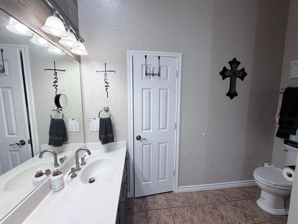 313 An County Road, Unit 2145 Palestine, TX 75801 - Photo 25 of 40 Dual basin vanity with a light-toned countertop, brushed nickel fixtures, and a wall-mounted light bar