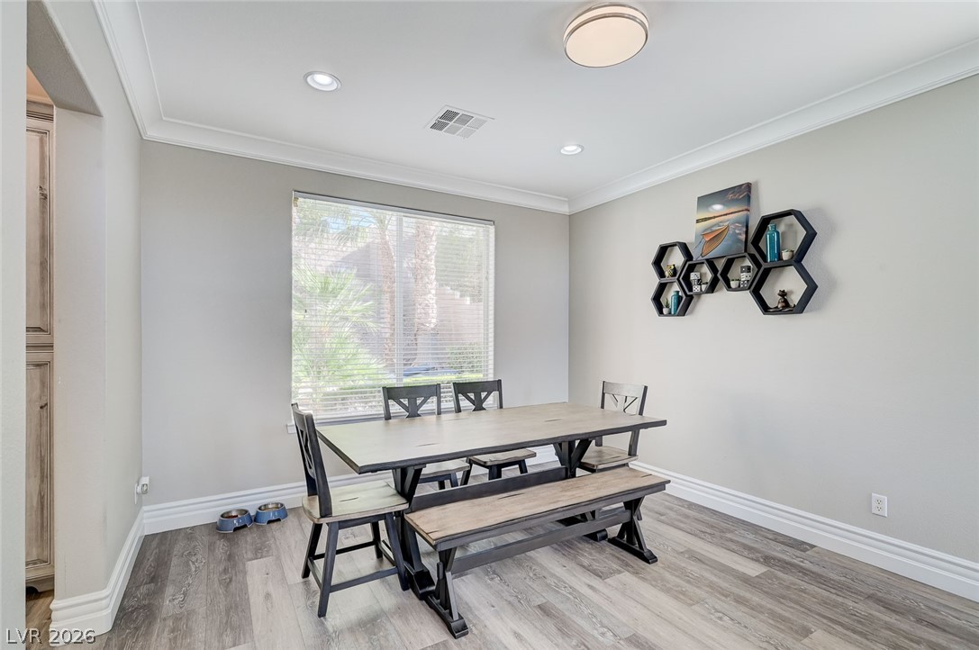 2391 Rainswept Avenue Henderson, NV 89052 - Photo 22 of 62 This bright dining area features elegant crown molding and durable wood-look flooring.