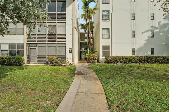a front view of a building with a garden